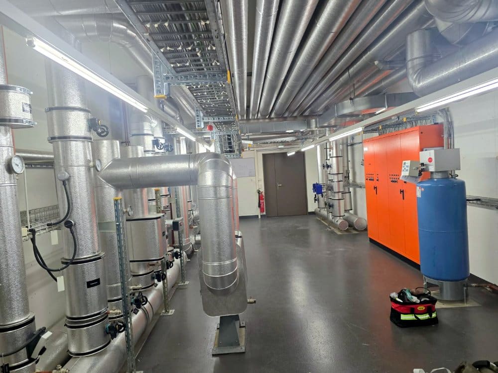 Technikgang mit isolierten Lüftungsleitungen und Absperrklappen, Flughafen Zürich