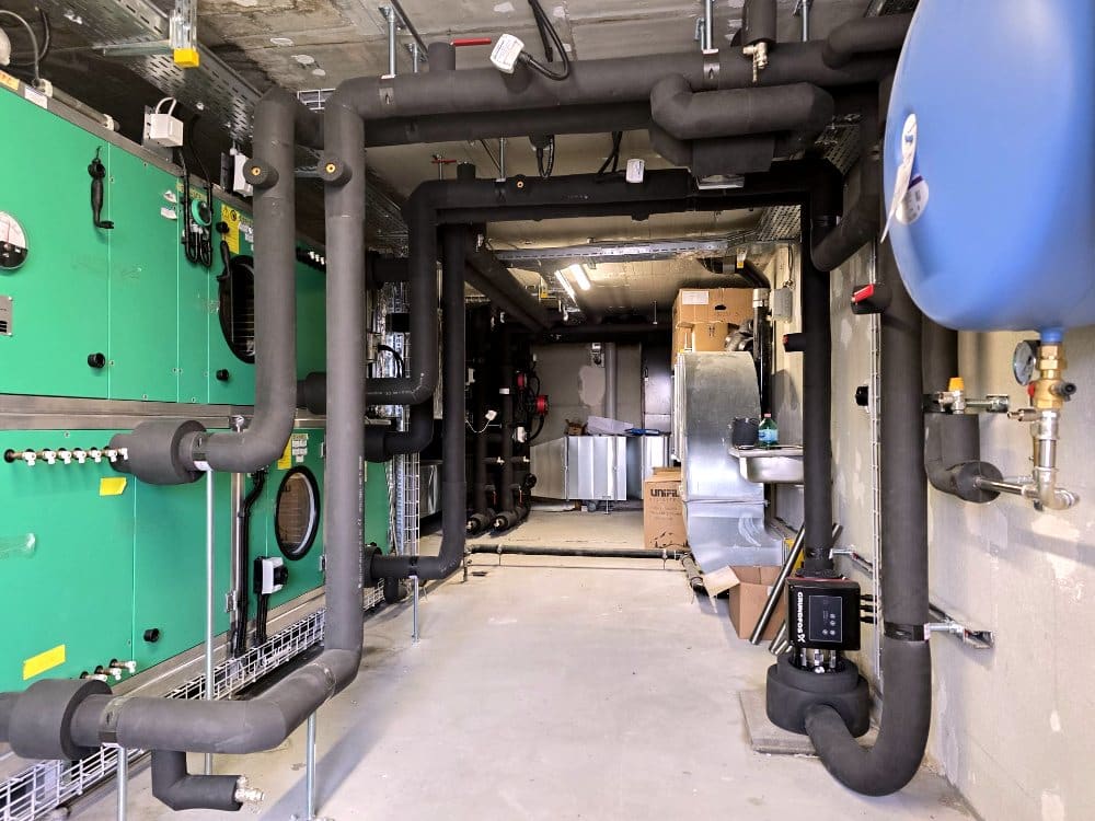Technikzentrale mit Kautschuk-isolierten Kälteleitungen und Lüftungsgeräten, Industriegebäude Zürich