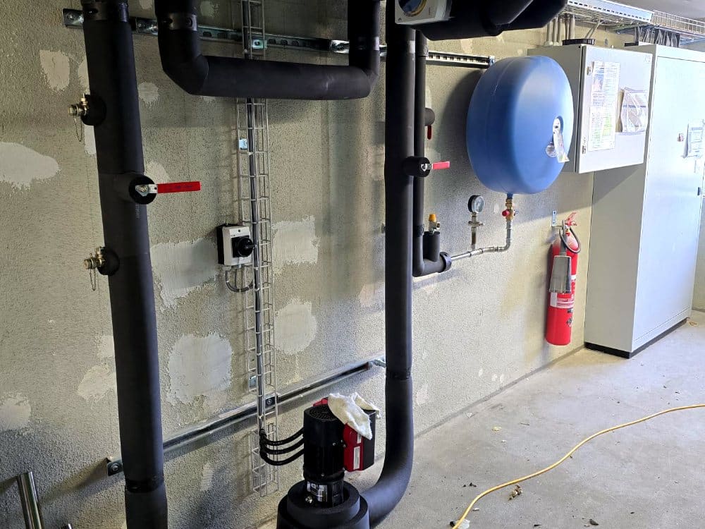 Isolierte Kälteleitungen mit Pumpe und Ausdehnungsgefäss, Industriegebäude Zürich