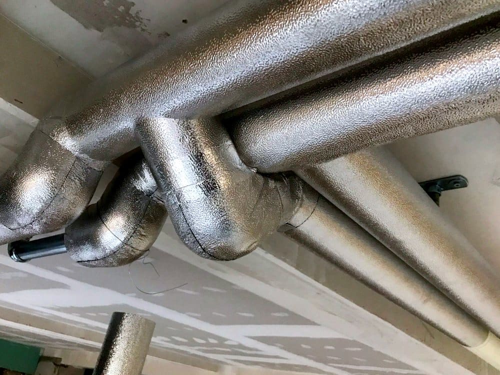 Detail der Blechverkleidung an Bögen und Abzweigen, Mehrfamilienhaus Zumikon